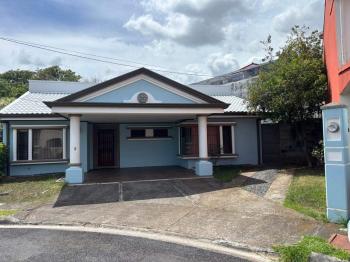 Fachada principal con zonas de parqueo techado y abierto